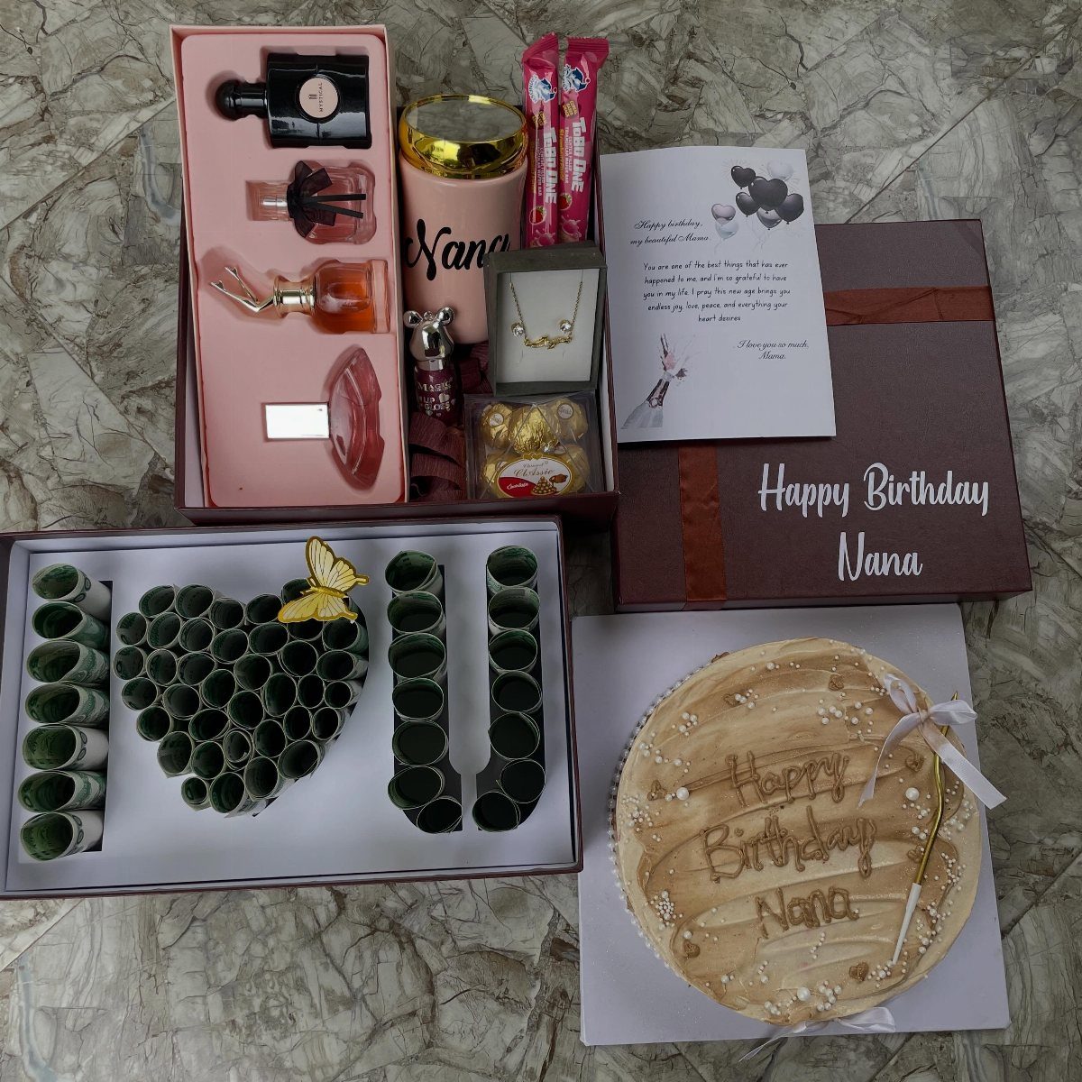 Birthday gift set for Nana featuring a cake, perfumes, jewelry, and chocolate letters.