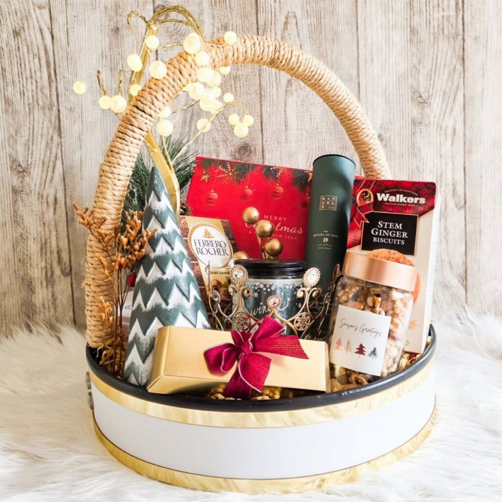 Gourmet food gift basket with ginger biscuits, chocolates, and nuts in a wicker basket.