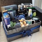 Grey woven gift basket filled with men's toiletries, a blue teddy bear, and a mug.