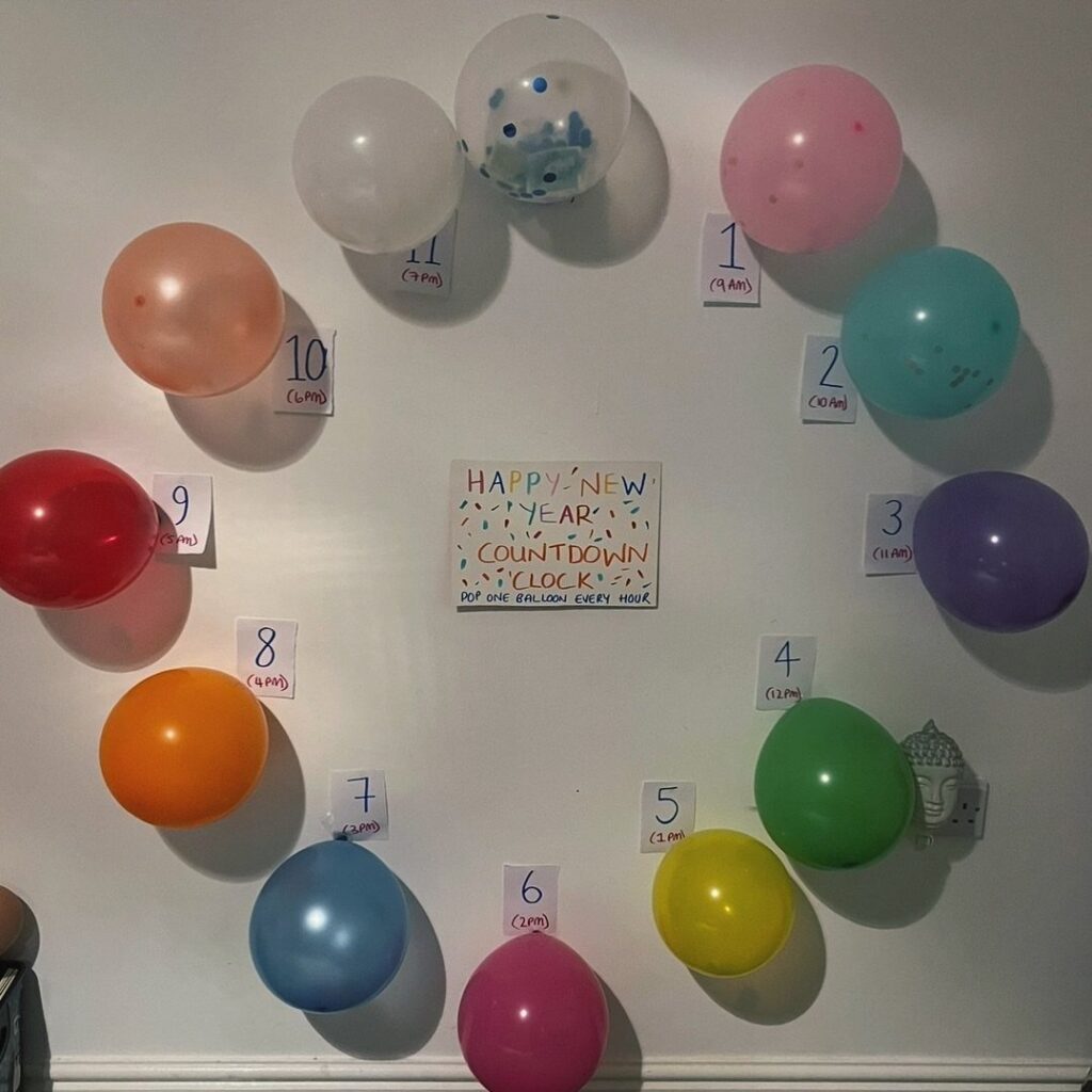 Colorful balloons arranged like a clock on a wall for a New Year countdown.