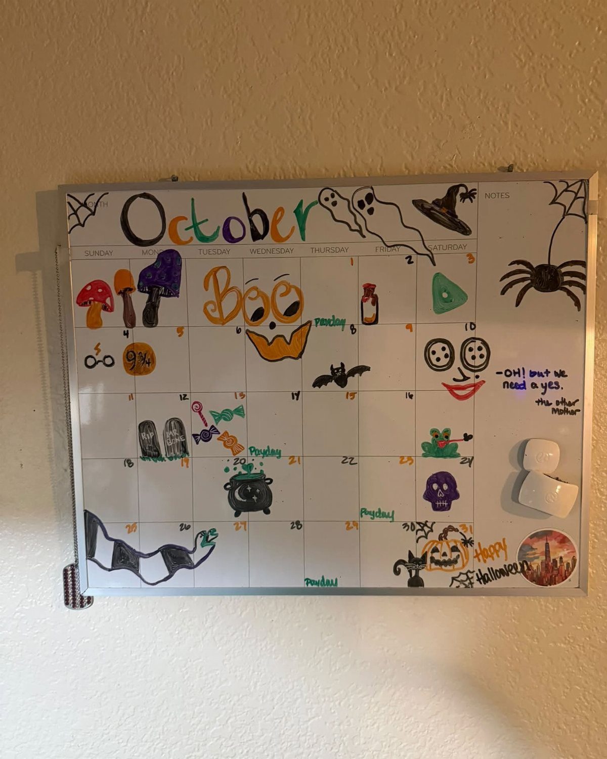 White board October calendar with colorful hand-drawn Halloween doodles and drawings on a wall